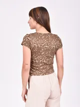 Remera marrón con estampado animal print, cuello redondo y mangas cortas.