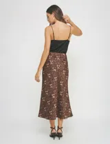Falda midi de satén con estampado animal print en tonos marrones y negros. Corte al bies que cae ajustado en la cadera y se abre ligeramente hacia el ruedo.