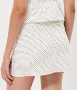 Mini short pollera de bengalina con estampado de lunares, diseño ajustado con cintura estructurada.