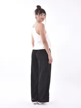 Pantalón negro de tiro alto, corte ancho y pierna recta, con cordón ajustable en la cintura.