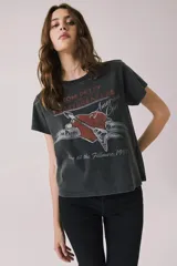 Remera gris oscuro de corte holgado, con cuello redondo y mangas cortas. Presenta un estampado frontal alusivo a Tom Petty and the Heartbreakers con motivos de corazón, guitarra y texto estilo vintage.