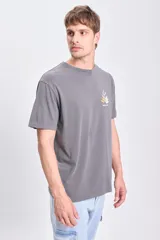 Remera gris oscuro de manga corta, corte oversize y estampa en la espalda con texto y diseño de hojas.