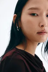 Top ajustado de manga larga, color borgoña oscuro, confeccionado en tejido elástico y semitransparente, con escote tipo cascada o drapeado.