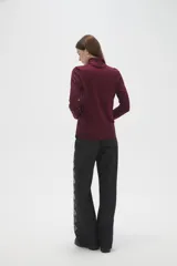 Polera de lyocell color negro, con cuello alto y ajuste al cuerpo, de manga larga.