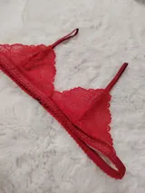 Bralette de encaje rojo con diseño triangular y tirantes ajustables finos.