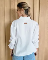 Blusa de algodón con cuello mao y volados, mangas largas con puños elásticos y corte holgado.