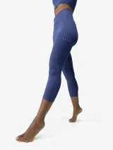 Calza capri seamless de tiro alto, confeccionada en tejido técnico Air_Feel con tecnología 3D. Presenta líneas laterales texturizadas que estilizan la silueta y detalles de puntos reflectantes en la parte inferior de la pierna.