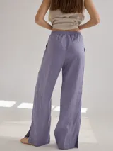 Pantalon de corte recto y tiro medio, confeccionado en lino, con cintura elastizada y tajos laterales en el ruedo.