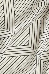 Pantalón de corte amplio y tiro alto, con cintura elástica y cordón de ajuste. Presenta un estampado geométrico en blanco y negro con líneas finas y formas entrelazadas.