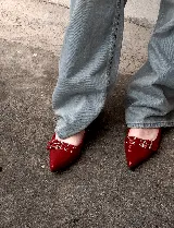 Chatas rojas de charol con punta fina y tiras con hebillas y ojalillos.