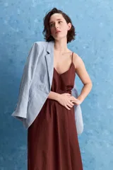 Vestido largo blanco de corte amplio y silueta recta, confeccionado en mezcla de lyocell, viscosa, nylon y lino. Tiene escote en V y breteles finos regulables.