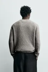 Sweater de punto color beige, de corte relajado, con cuello redondo y diseño texturizado en estructura waffle.