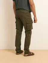 Pantalón cargo color verde militar, de corte recto, con bolsillos laterales con fuelle, bolsillos delanteros inclinados y bolsillos traseros.