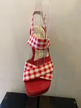 Sandalias rojas con plataforma y taco ancho. Tiras de tela con estampado de cuadros vichy rojos y blancos, y tira al tobillo con hebilla.