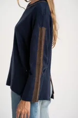 Sweater de tejido de punto con calce oversize, color azul marino con detalles en color marrón en las mangas y cuello. Presenta un diseño de manga larga y puños y ruedo acanalados.