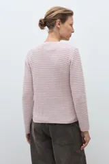 Chaqueta de punto color celeste, con cuello redondo, manga larga y cierre frontal con botones metálicos plateados.