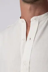 Camisa de manga larga color blanco roto, confeccionada en una mezcla de lino y viscosa, con cuello mao y corte relajado.