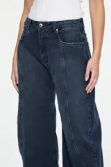 Pantalón de denim azul oscuro con corte balloon, tiro medio, costuras curvas decorativas en el frente y diseño de cinco bolsillos.