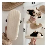 Pantuflas de peluche con diseño de vaca, confeccionadas en piel sintética suave. Cuentan con suela de goma antideslizante y diseño abierto en el talón.