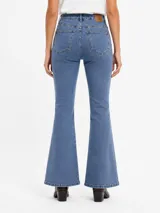 Jean de denim azul de corte flare, con tiro medio, diseño de botamanga acampanada y sutil estampado texturizado en toda la prenda.