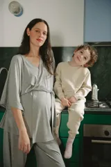 Conjunto de pijama y bata para maternidad/lactancia en tejido acanalado gris. La bata es cruzada con lazo y la parte inferior son pantalones anchos.