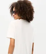 Remera de algodón color blanco, de corte holgado y manga corta, con cuello redondo y estampa frontal en negro con la inscripción "Butterfly Effect" y un diseño de mariposa.