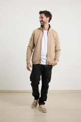 Cardigan de tejido de punto color verde militar, con cierre frontal de metal y cuello redondo. Presenta bolsillos laterales con detalle de tejido plano y tirador de eco cuero en el cierre.