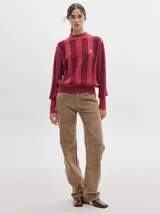 Pantalón de tiro medio confeccionado en pana color rojo, con corte holgado y detalle de línea lateral en contraste.