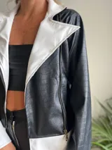 Campera de cuero sintético negra con textura de cocodrilo, con cuello, solapas y puños en color blanco.