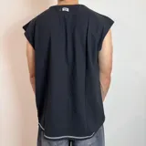 Musculosa de corte oversize color blanco con costuras expuestas en color negro que recorren el centro y los hombros.
