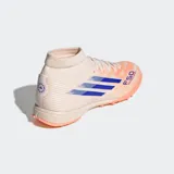 Championes de fútbol Adidas F50 Sparkfusion League, diseñados para mujer. El calzado es de caña media con cuello tejido, exterior en tono beige claro con franjas azules y detalles en naranja coral en la suela.
