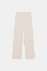 Pantalón de tiro alto con pernera recta y nervio marcado en el delantero. Cuenta con cintura elástica en la parte posterior, bolsillos delanteros y bolsillos de plastrón en la parte trasera. Cierre frontal con botón interior y ganchos.