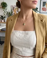 Collar de bronce dorado con cadena fina y dije circular con diseño de Yin Yang pavimentado con circones negros y blancos.