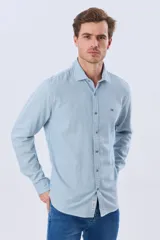 Camisa de manga larga confeccionada en mezcla de lino y algodón, con diseño de rayas finas, cuello camisero y cierre frontal de botones.