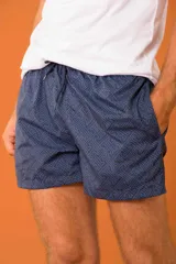 Short de baño azul marino con estampado de flores celestes, cintura elástica regulable con cordón y bolsillos laterales.