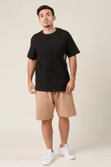 Bermuda de friza color gris melange, de corte suelto, con cintura elástica y cordón de ajuste negro.