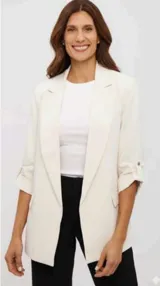 Blazer color crudo de corte recto, con solapas clásicas y mangas tres cuartos con detalle de trabilla y botón. Presenta bolsillos laterales con solapa.