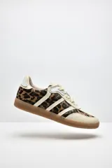 Zapatillas Adidas Samba con estampado animal print en blanco y negro, detalles en cuero beige y suela de goma color caramelo.