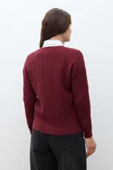 Cardigan de punto con textura de tejido estructurado, color bordó, con cuello redondo, cierre frontal de botones y mangas largas.