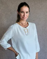 Blusa de mangas tres cuartos con diseño de corte recto y cuello redondo. Presenta costuras horizontales decorativas en las mangas y un acabado liso.