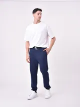 Pantalón de jogging negro con cintura elástica ajustable mediante cordón, bolsillos laterales y puños elásticos en los tobillos.