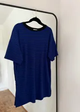 Remerón/vestido corto azul con rayas horizontales negras, corte holgado y tajos laterales.