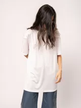 Remera blanca oversized de tela elastizada con tajos laterales y escote redondo.
