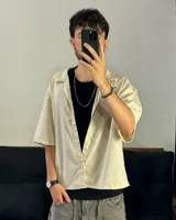 Camisa beige de corte boxy fit, manga corta y confeccionada en lino viscosa.