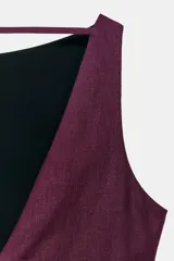 Vestido midi de color bordó, sin mangas, con cuello redondo y diseño asimétrico con frunces en el delantero.