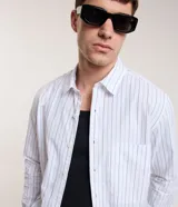 Camisa de manga larga con cuello inglés, confeccionada en algodón con estampado de rayas verticales.