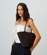 Cartera shopper de diseño estructurado en forma de trapecio invertido, color marrón oscuro, con asas de hombro y detalles metálicos dorados.
