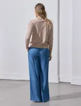 Cárdigan negro tejido en hilado fino con escote en V y un botón.