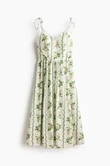 Vestido midi en popelina de algodón blanco con estampado floral y de enredaderas verdes, escote corazón, tirantes finos con lazo y falda con vuelo.