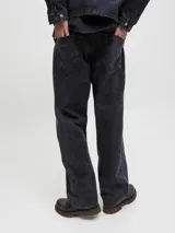 Pantalón de corte baggy y tiro alto, confeccionado en denim con efecto lavado ácido en color negro. Presenta una silueta amplia y relajada, con bolsillos funcionales y cierre frontal.
